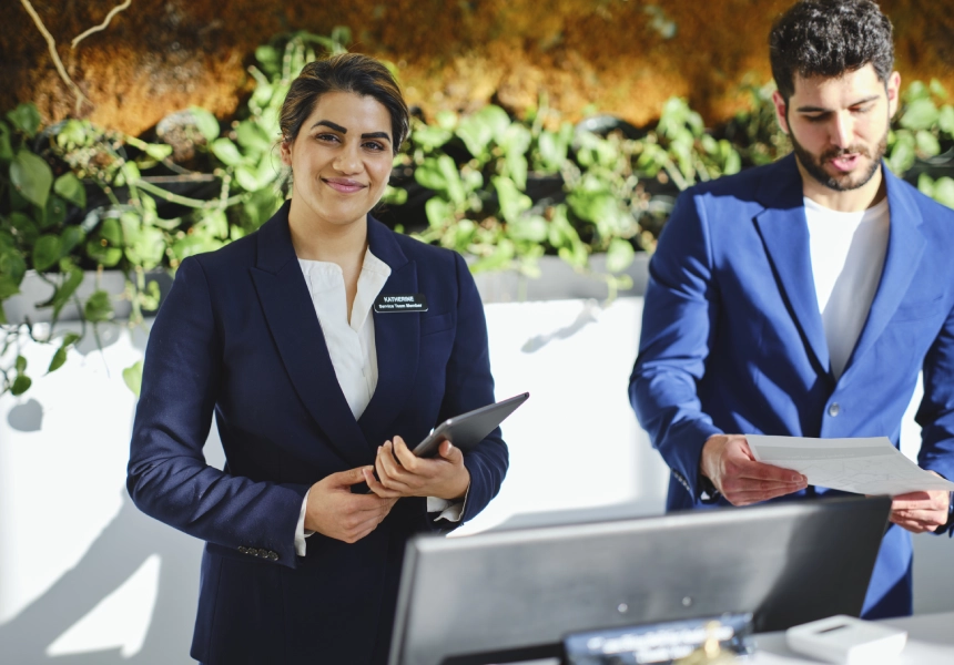 Hotel receptionists working at a desk.