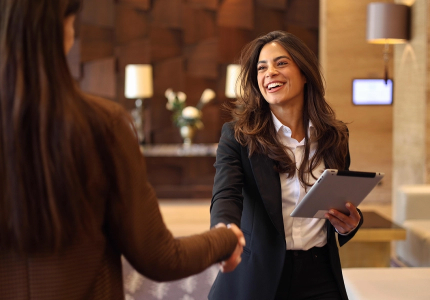 Smiling businesswoman shaking hands, tablet.
