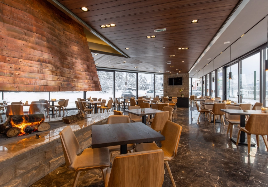 Restaurant interior with fireplace and wooden tables.