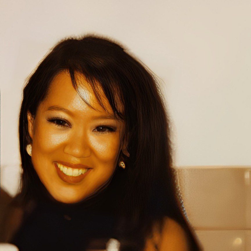 Smiling woman with dark hair and earrings.